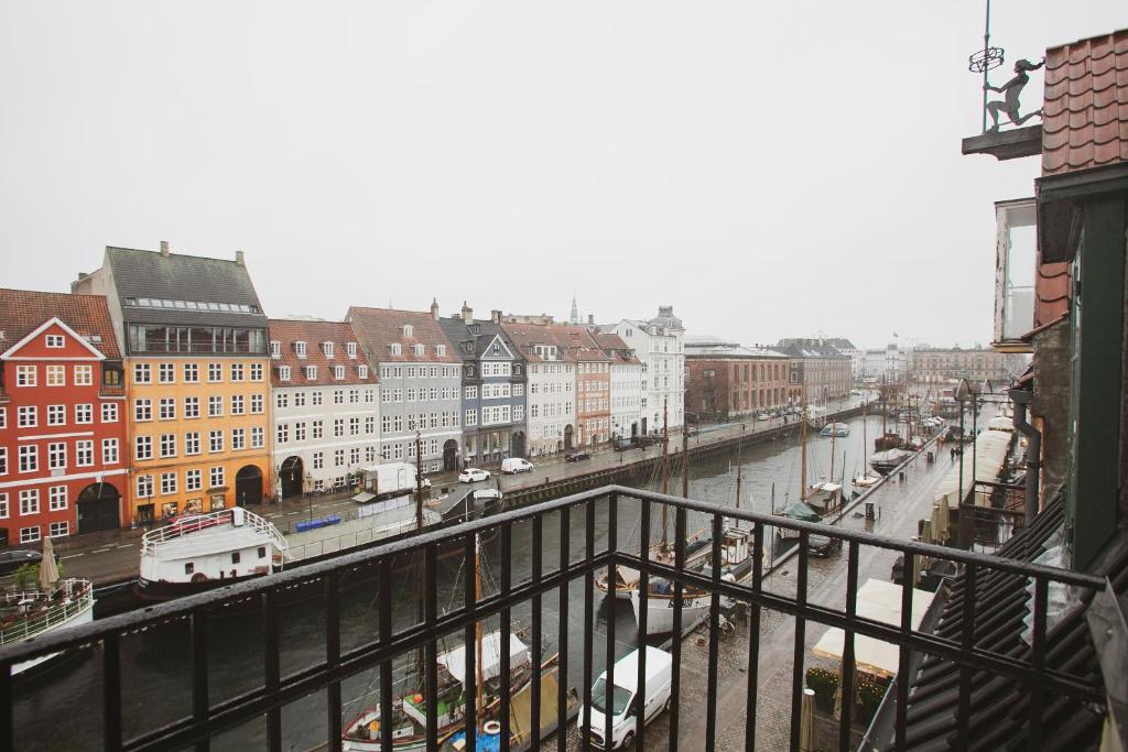 a view of a city with a river and buildings at Modern 3BR Duplex Apartment in Nyhavn w Private Balcony in Copenhagen