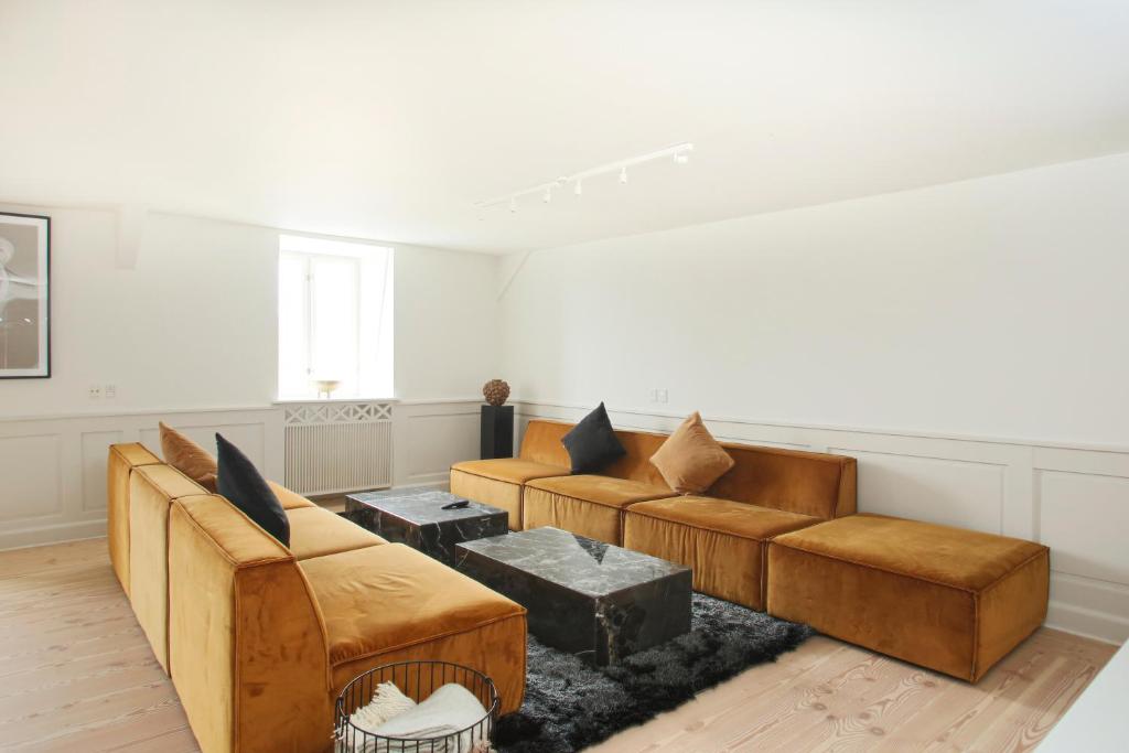 a living room with couches and a table at Modern 3BR Duplex Flat in Nyhavn w Private Balcony in Copenhagen