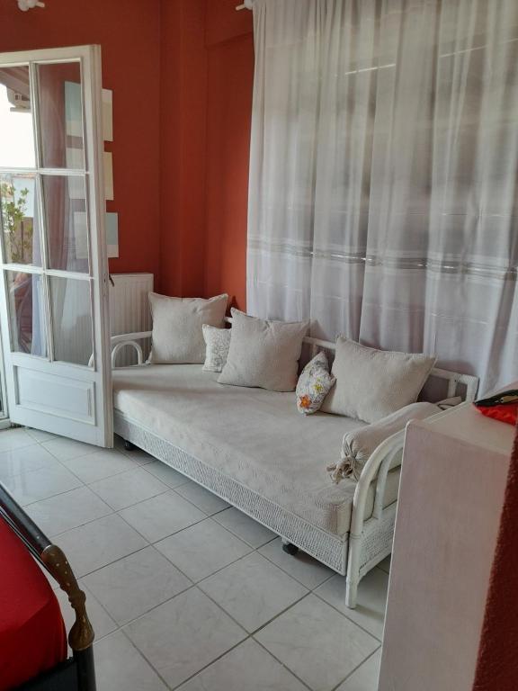 kanapę siedzącą w pokoju z oknem w obiekcie Cozy maisonette in Pefkochori Chalkidiki w mieście Pefkochori