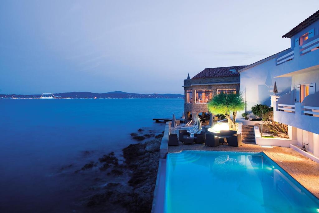 a house with a swimming pool next to the water at La Belle Aurore in Sainte-Maxime