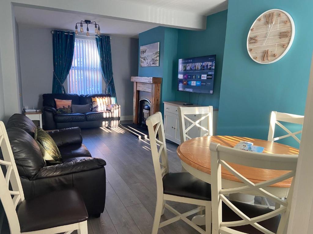 a living room with a table and a dining room at Glenbann House in Coleraine