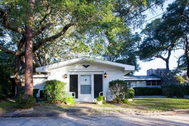 a white house with a tree in front of it at SEA COTTAGE APARTMENT Duplex in Jekyll Island