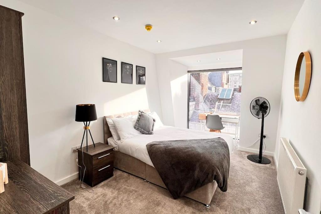 a white bedroom with a bed and a window at Luxury Penthouse in Merseyside, Waterfront in Liverpool