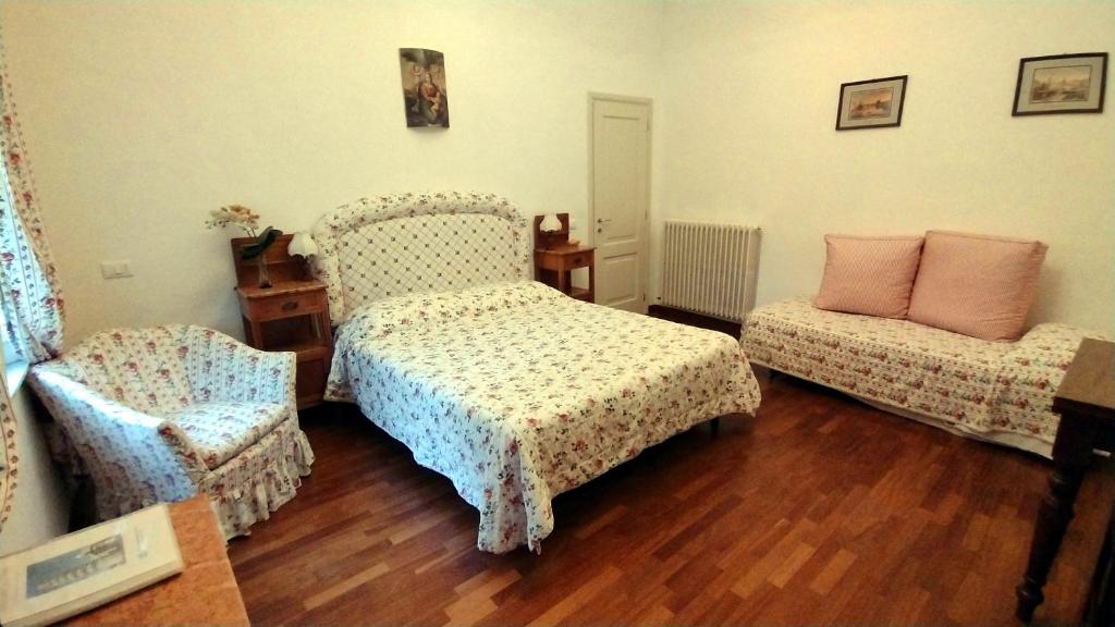 1 dormitorio con 1 cama y 1 silla en Il Campanile II Locazione Turistica, en Pisa