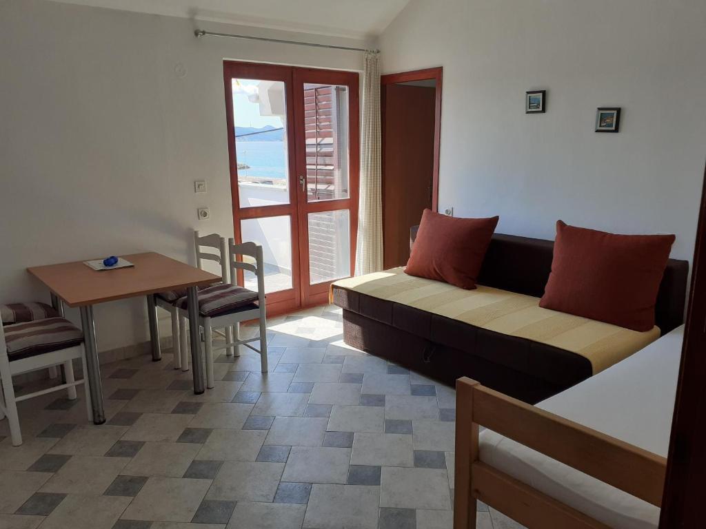 salon z kanapą, stołem i oknem w obiekcie vala apartmani w Bibinje