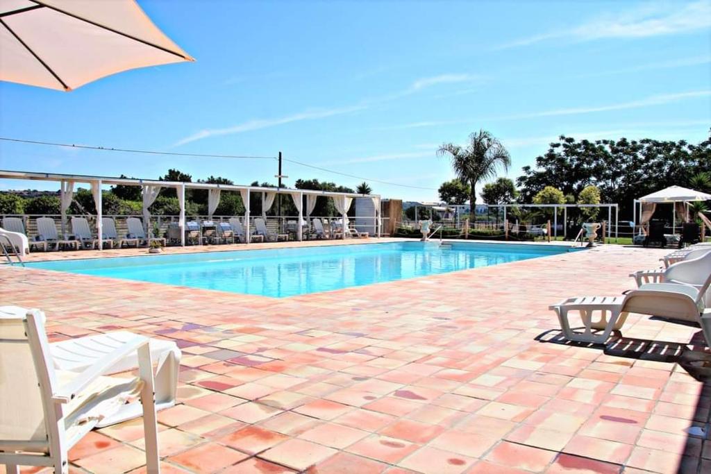 una piscina con sedie a sdraio e ombrellone di Casa vacanze Barbera con piscina a Santa Lucia