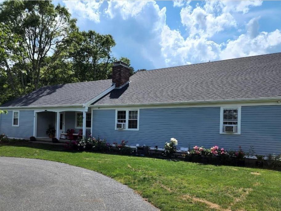 a blue house with flowers in the yard at Thompson House Cape Cod in South Yarmouth