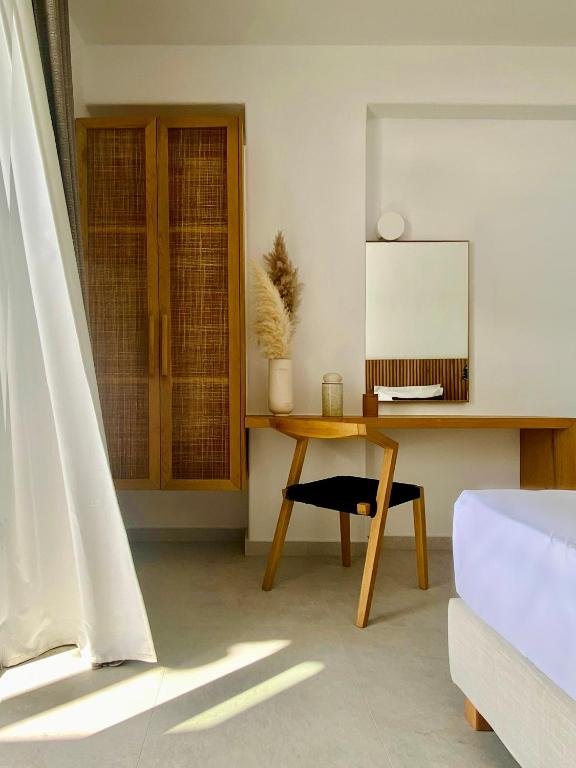 a room with a desk and a table with a mirror at Calistus Mykonos in Mikonos