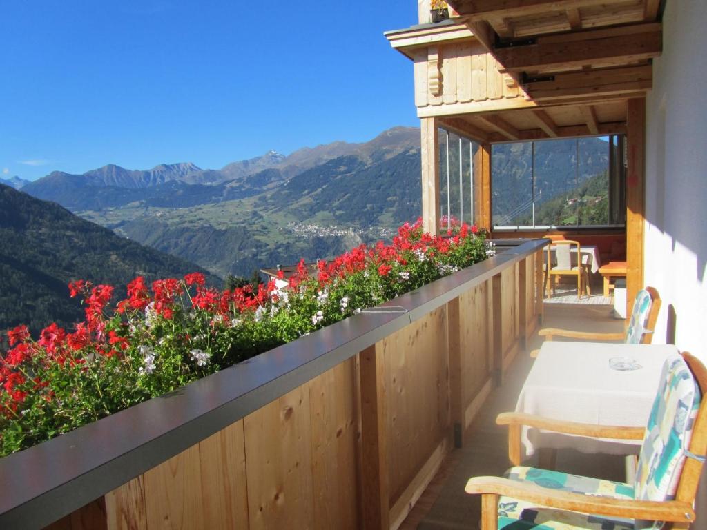 a balcony with flowers and a table and chairs at Haus Lentsch in Kaunerberg