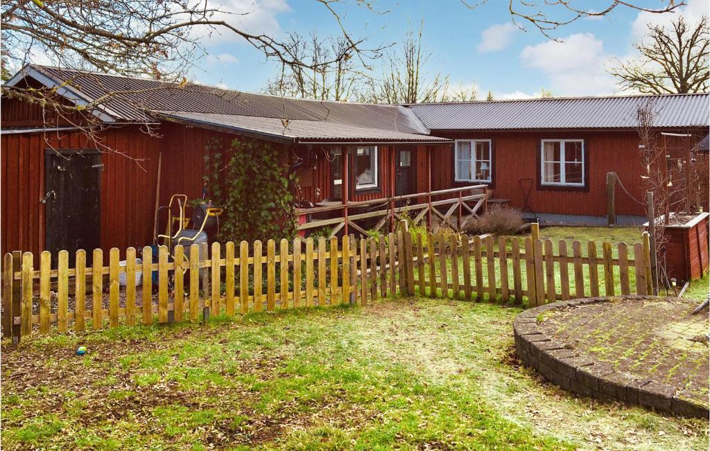 a wooden fence in front of a red house at Lovely Home In Kosta With Wifi in Kosta