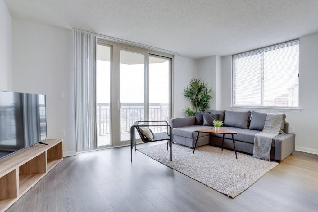 a living room with a couch and a table and a tv at Fantastic 2 BR Condo at Ballston With City View in Arlington