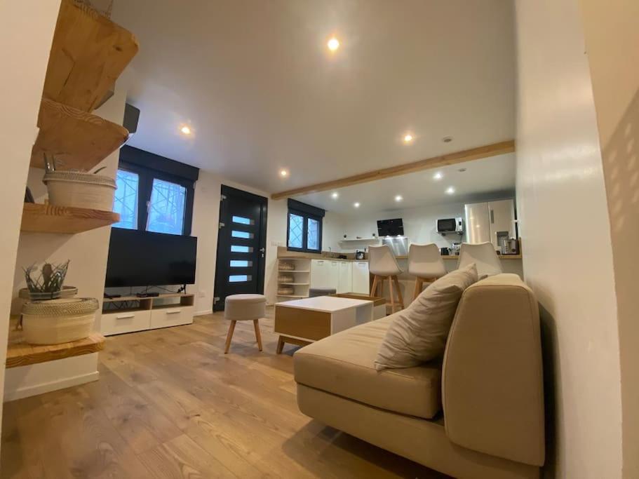 a living room with a couch and a kitchen at ÉDEN in Vitry logement entier in Vitry-sur-Seine