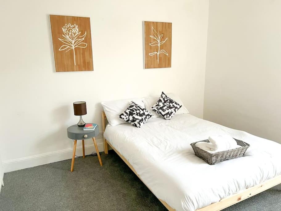 um sofá branco num quarto com uma mesa lateral em City centre terrace town house em Nottingham