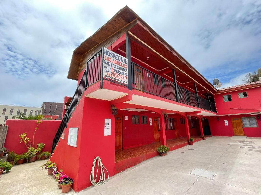 un edificio rosso con un pavimento rosso di Hospedaje Los Abuelos a Pichilemu
