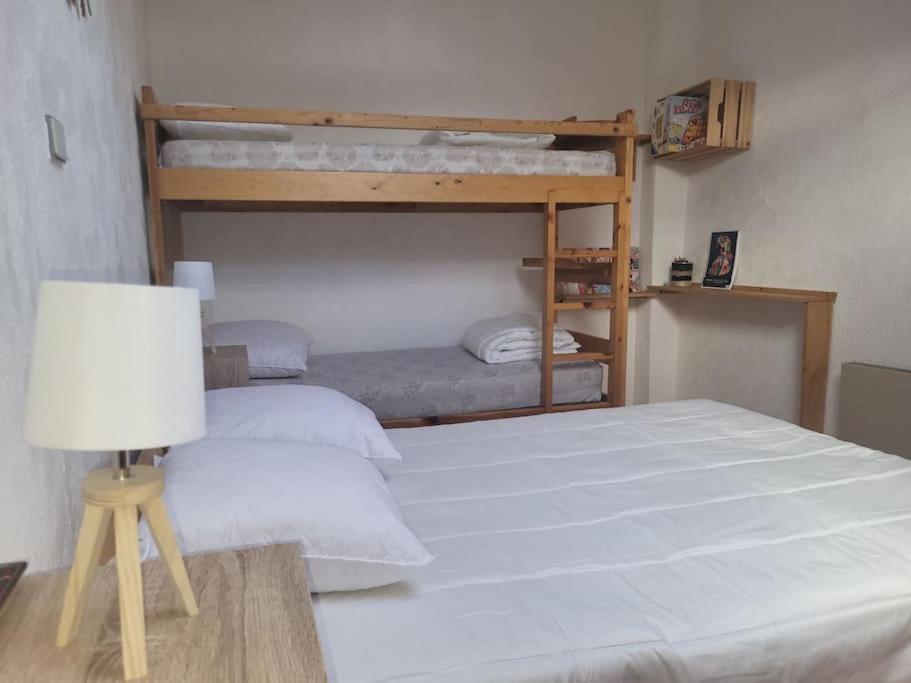 une chambre avec deux lits superposés et une lampe dans l'établissement Appartement saisonnier, à Saint-Bonnet-en-Champsaur