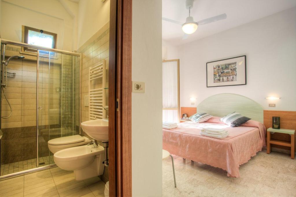 sypialnia z łóżkiem oraz łazienka z prysznicem w obiekcie Albergo Villa Lucia w mieście Bellaria-Igea Marina