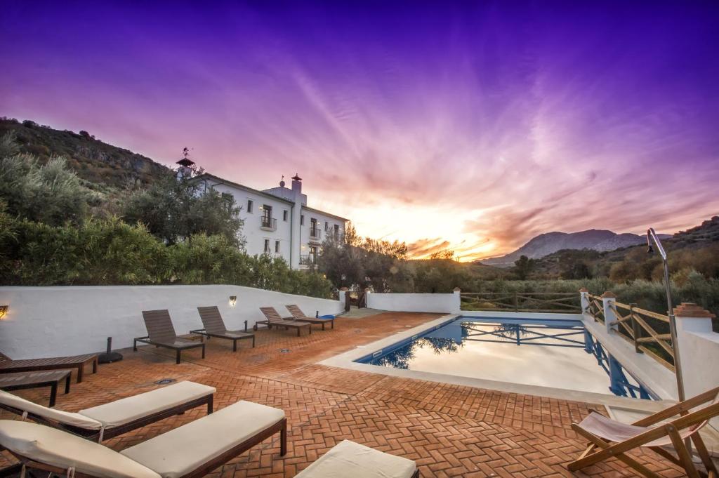 une villa avec une piscine au coucher du soleil dans l'établissement Casa Olea hotel rural, à Priego de Córdoba