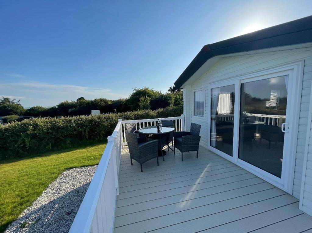 a wooden deck with a table and chairs on it at Newperran 102 in Cubert