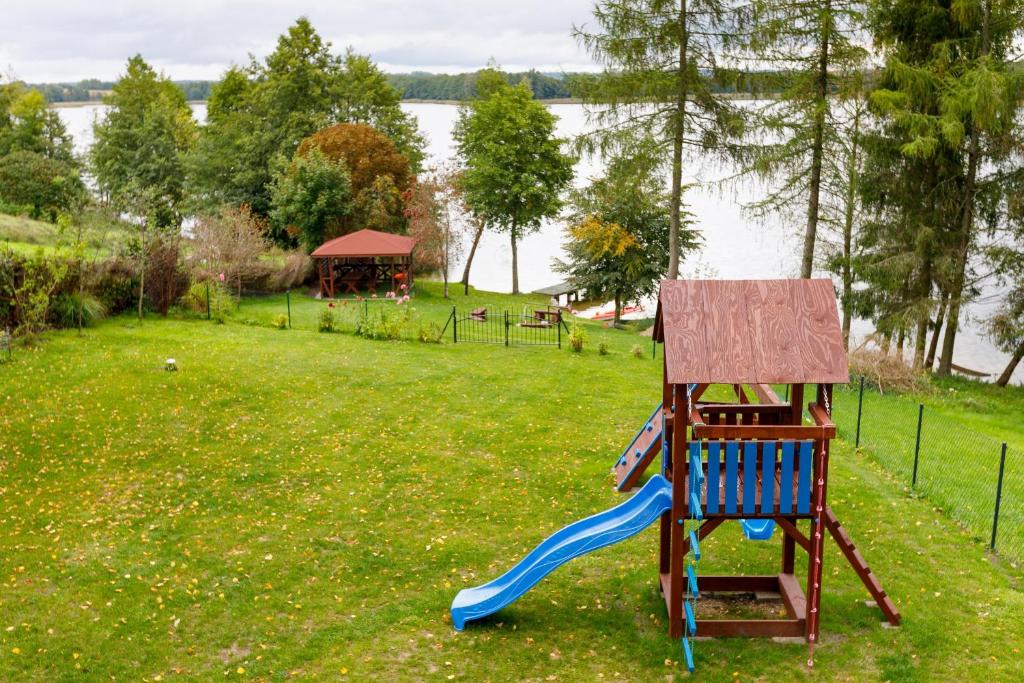 une aire de jeux avec un toboggan bleu dans un parc dans l'établissement Alichatka, à Sołtmany