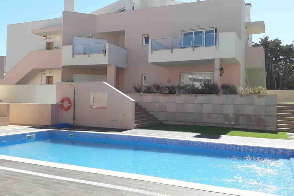 uma casa com piscina na frente de uma casa em Burgau 2floor appt in condominium w/ shared pool no Burgau