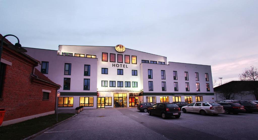 un hotel con coches estacionados en un estacionamiento en Hotel GIP en Grosspetersdorf