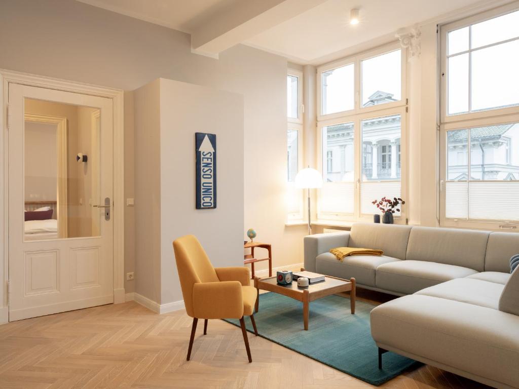 a living room with a couch and a table at OSTKÜSTE - Villa Groth Design Apartments in Heringsdorf