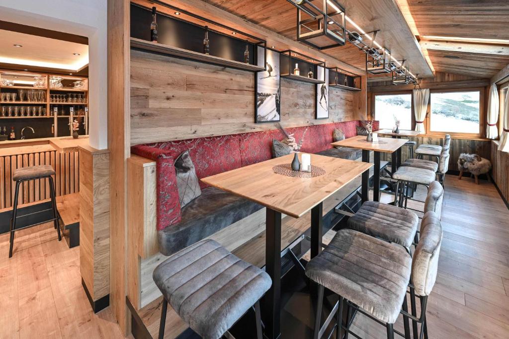 um restaurante com paredes de madeira e mesas e cadeiras de madeira em Hotel Sonnfeld em Hinterstoder
