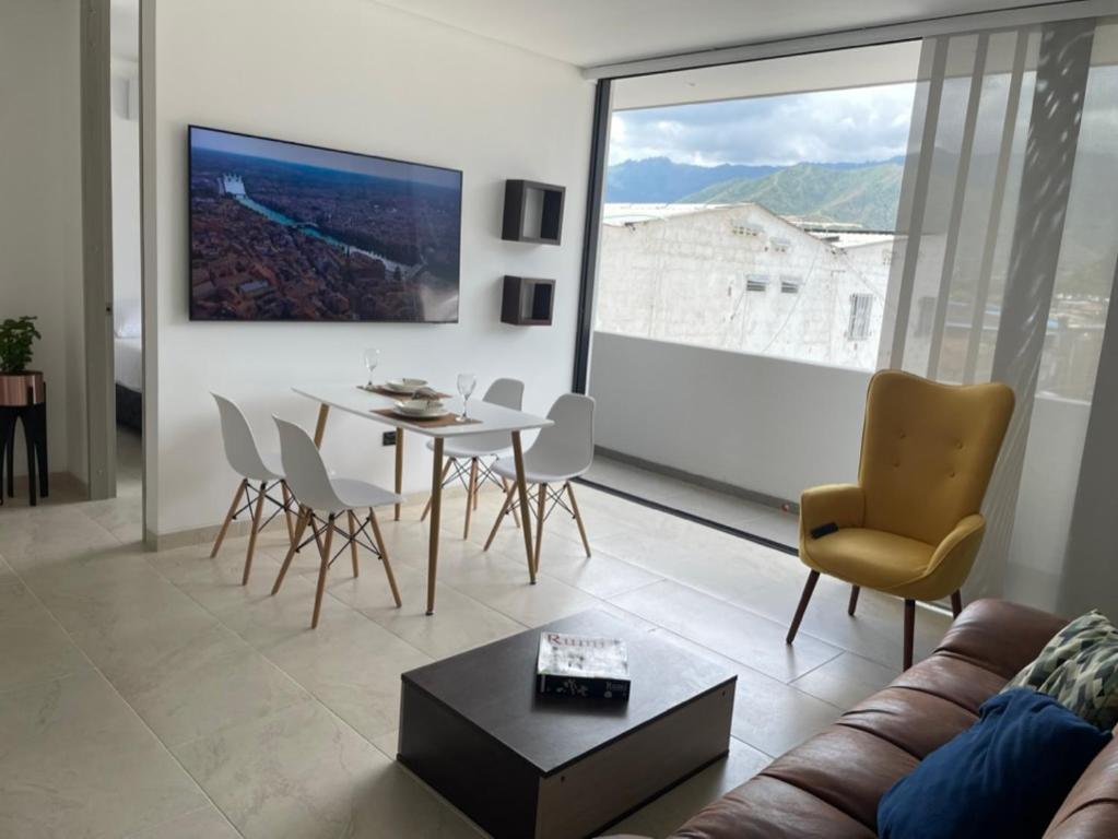 a living room with a couch and a table and chairs at DIMALU LOFT in Roldanillo