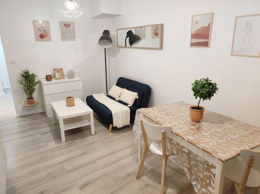 - un salon avec une table et un canapé dans l'établissement Charmant appartement avec terrasse proche Paris, à Le Perreux-Sur-Marne