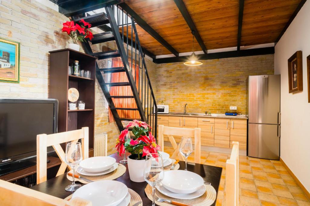 a dining room with a table and chairs and a kitchen at El Paraíso del Olivar in Bollullos de la Mitación