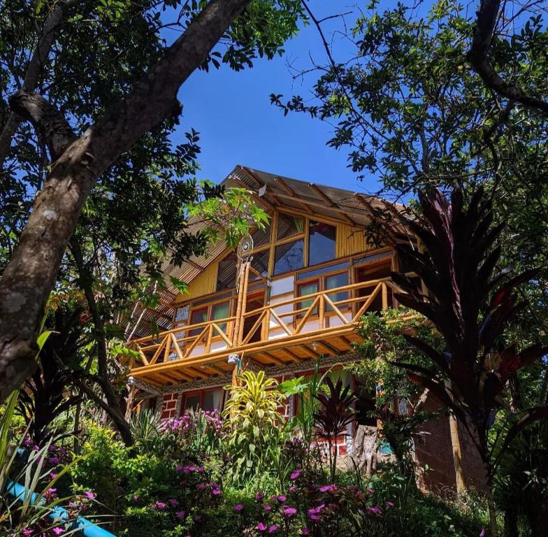 Casa de madera con balcón en medio de árboles en Alojamiento Rural Manu Viajeros, en San Agustín