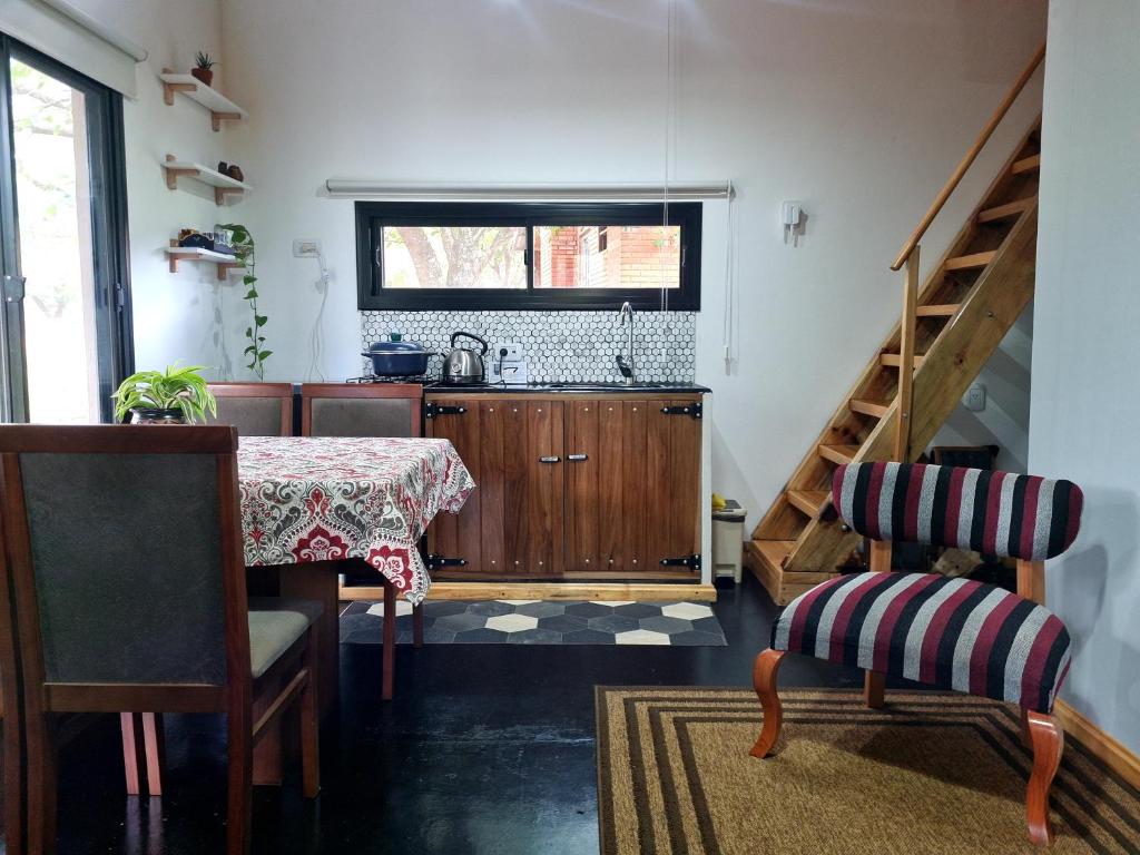 una cocina con mesa, lavabo y escalera en Minicasa rural "El Sitio de la Vida" en Wanda