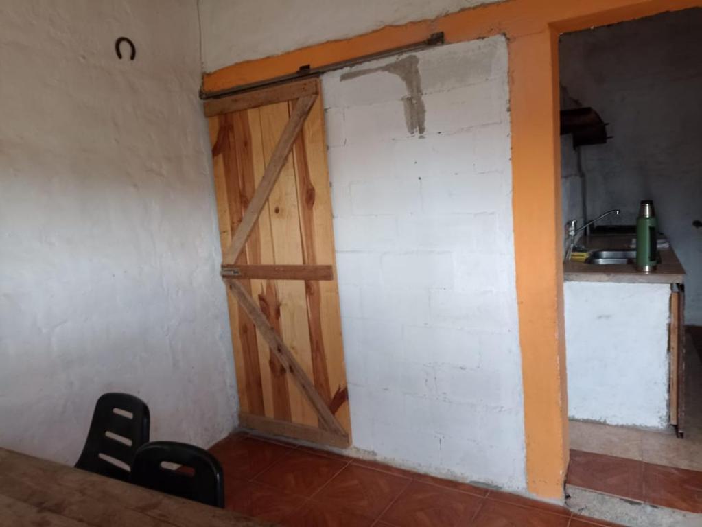 Habitación con puerta de madera. en Casa CAMALDALU en Unquillo