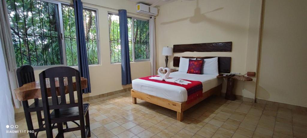 ein Schlafzimmer mit einem Bett in einem Zimmer mit Fenstern in der Unterkunft Casa Hadassa La Cañada in Palenque