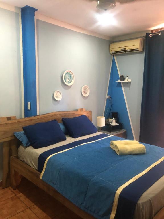 1 dormitorio con 1 cama con sábanas azules y blancas en Toucan House, en Coco