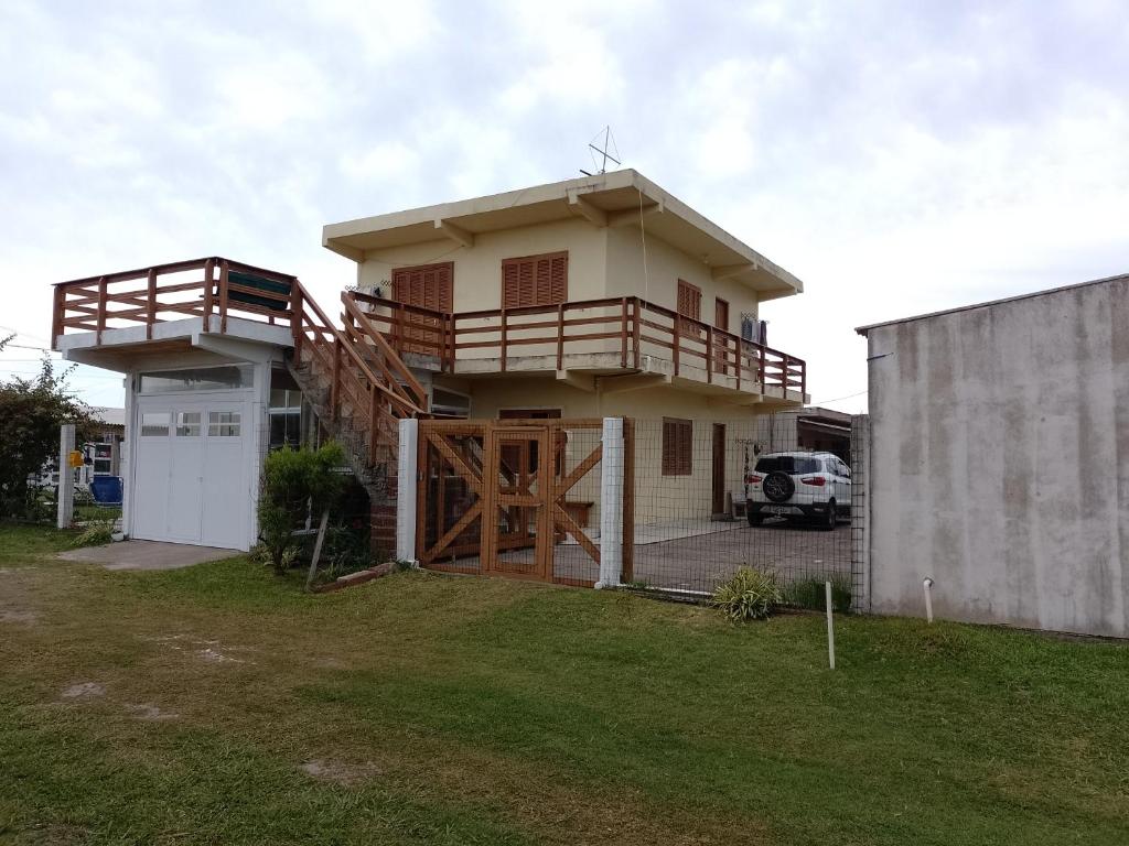 ein Haus mit Balkon darüber in der Unterkunft Pousada do Osvaldo Imbé in Imbé