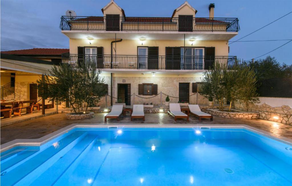 uma villa com piscina em frente a uma casa em Stunning Home In Unesic With Jacuzzi, Wifi And Outdoor Swimming Pool em Unešić