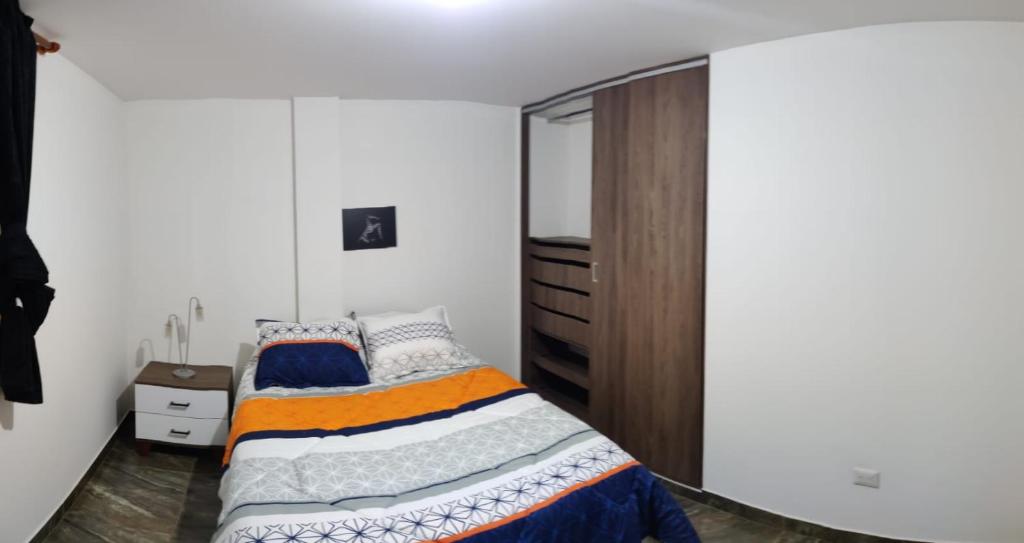 a bedroom with a bed and a dresser at Que chimba de apto. in Bogotá