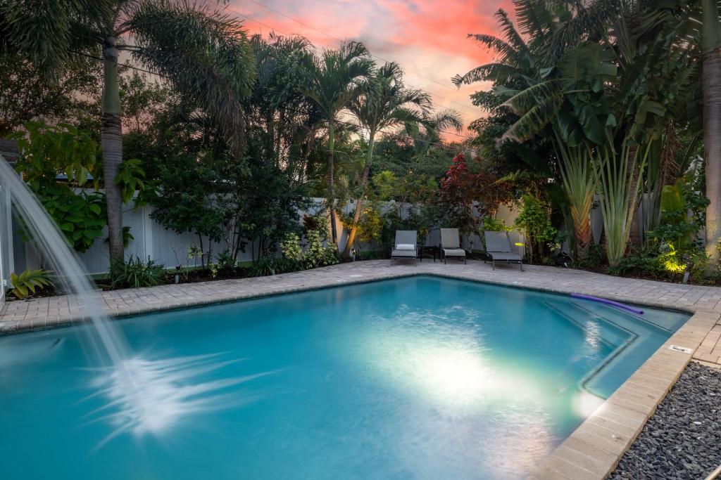 a swimming pool in a backyard with palm trees at Wilton Manors Cottage West 2 Bed 2 Bath With Pool in Fort Lauderdale