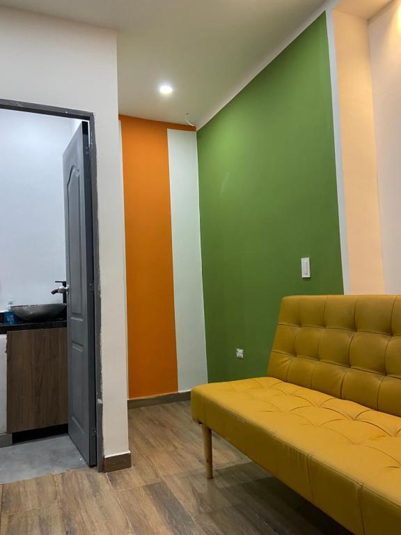 sala de estar con sofá amarillo y paredes verdes en Loft La 70 Laurles Estadio, en Medellín