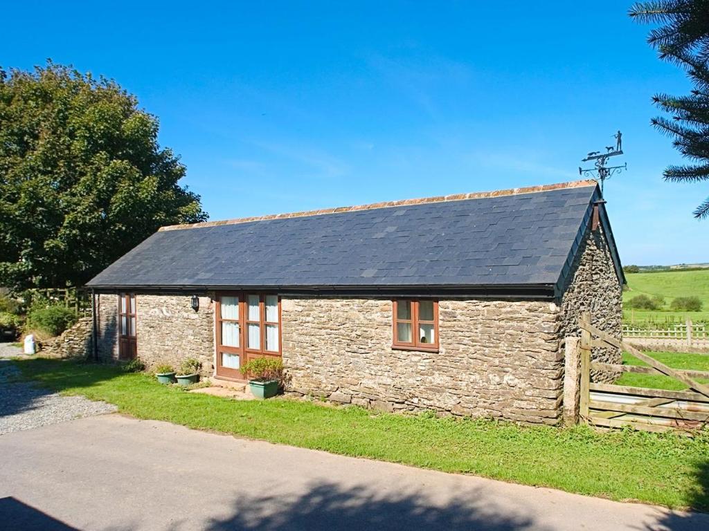 a stone cottage with a solar roof on a road at The Mealhouse-UK12902 in Pelynt