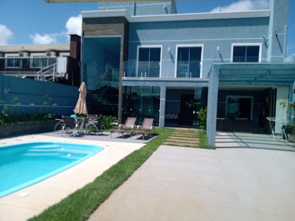 ein Haus mit einem Pool neben einem Gebäude in der Unterkunft Casa alto padrão Matinhos in Matinhos
