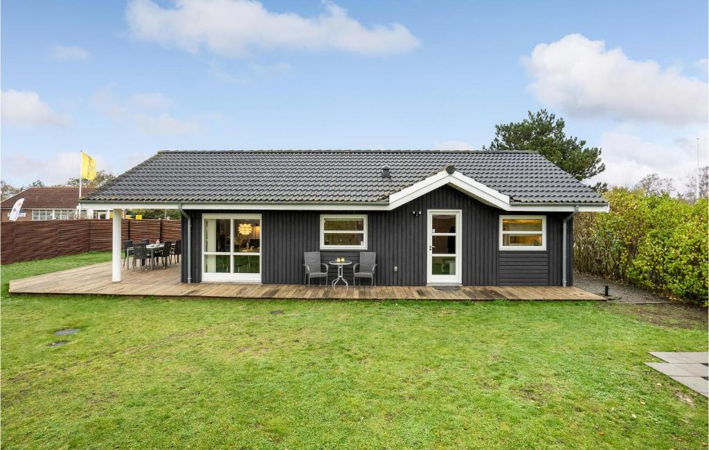 una pequeña casa negra con terraza de madera en Nice Home In Slagelse With Wifi, en Slagelse