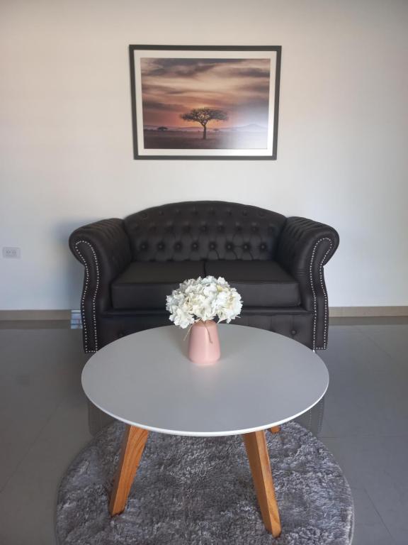 uma mesa de café branca com um vaso de flores em Quinta Ramona em Máximo Paz