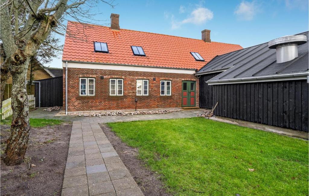 a brick house with an orange roof and a yard at 2 Bedroom Cozy Apartment In Ribe in Ribe