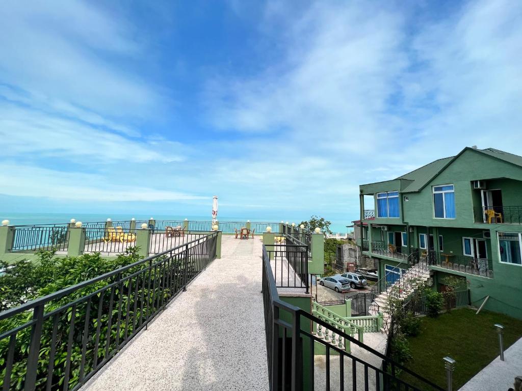 einen Balkon mit einem Haus und dem Meer im Hintergrund in der Unterkunft Inn David in Chakvi