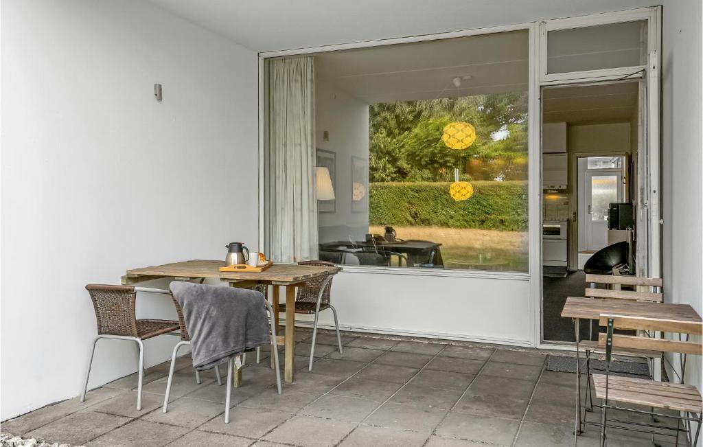 eine Küche mit einem Tisch und Stühlen sowie einem großen Fenster in der Unterkunft Awesome Apartment In Faaborg With Kitchen in Fåborg