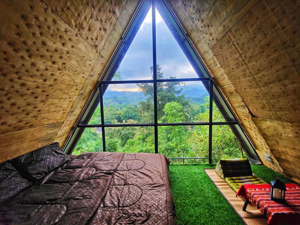 ventana grande en una habitación con cama y césped verde en Flower hill 180 en Chiang Rai