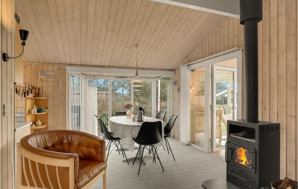 sala de estar con chimenea y mesa con sillas en Awesome Home In Lkken With Wifi, en Løkken