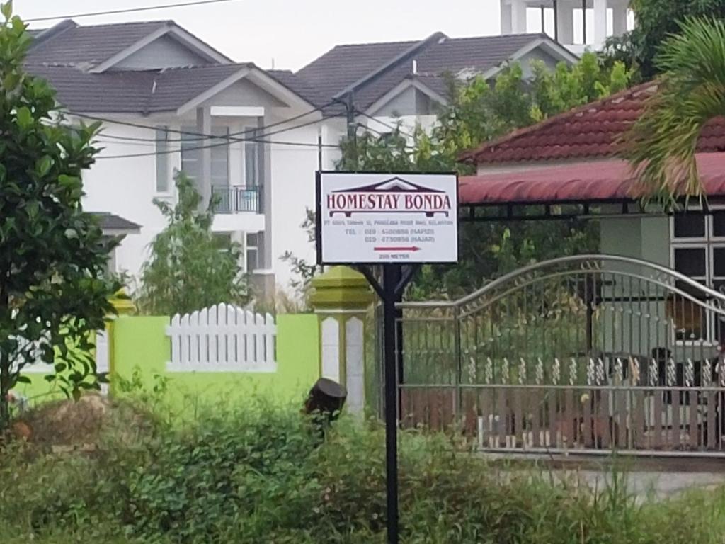 a sign for a house in front of a fence at HOMESTAY BONDA PASIR MAS, KELANTAN in Pasir Mas